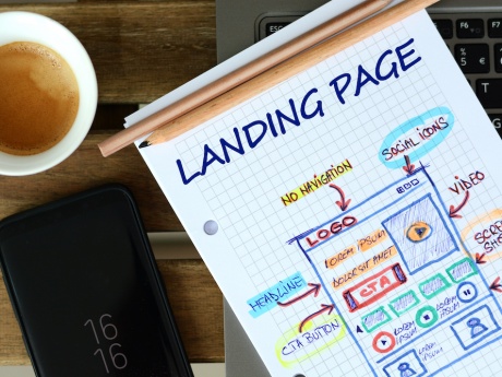 sheet of paper that says landing page with illustration next to coffee cup