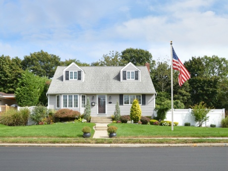 cape cod house with flag in front lawn