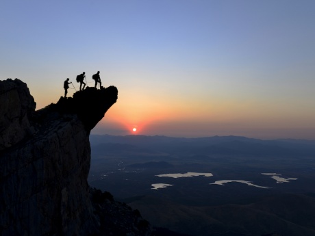 people climbing mountain at sunrise